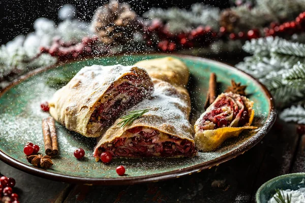 Strudel with a cherry. . winter dessert strudel with cherry, cranberries and walnut. Food recipe background. Close up.