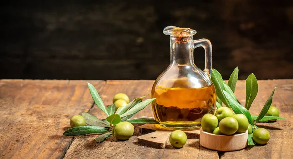 Olive oil in bottles with black and green olives and leaves. extra virgin olive oil jars on a wooden background. place for text.