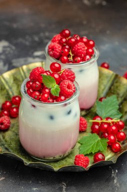 Böğürtlen yoğurdu. Yoğurt, reçel, frenk üzümü ve ahududulu sağlıklı katmanlı tatlı. dikey görüntü. Üst Manzara. metin için yer,