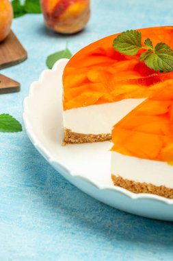 Şeftalili jöleli cheesecake. Restoran menüsü, diyet, yemek kitabı tarifi. dikey görüntü. Üst Manzara. metin için yer.