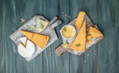 Parmesan peyniri. Koyu arkaplanda bıçak olan farklı peynir türleri. Cheeses set dor blu chedar camamber brie. metin için yer, üst görünüm.