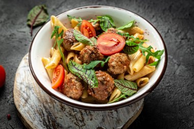 Köfteli makarna ve gri arka planda baharatlı domates sosu. Restoran menüsü, diyet, yemek kitabı tarifi afişi, metin yeri, üst görünüm.