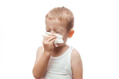 Küçük bir çocuk burnunu ıslak bir peçeteyle beyaz arka plana siliyor, hijyen ıslak mendilleri dikkatlice temizliyor.,