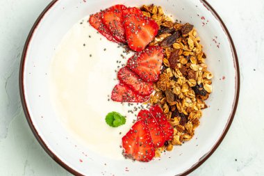 Yoğurtlu granola, taze çilek, chia tohumu ve bal beyaz arka planda. Lezzetli dengeli gıda konsepti. afiş, menü, metin için tarif yeri, üst görünüm.