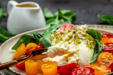 Burrata peyniri. Koyu arkaplanda taze sebze salatası. Sağlıklı beslenme konsepti. Restoran menüsü, diyet, yemek kitabı tarifi üst görünümü.