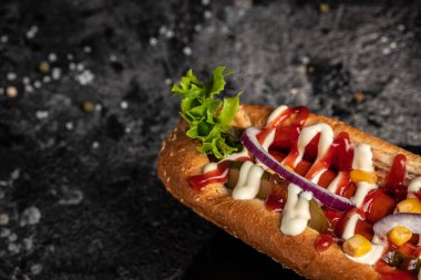 Farklı sosisli sandviçler ve koyu bir arka plan. Yemek arkaplanı. Fast food ve abur cubur konsepti, sokak yemekleri.