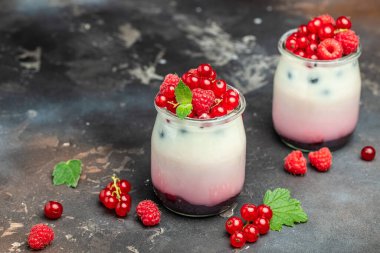 Ahududulu tatlı peynirli kek, ıvır zıvır, bardaktaki fare. Ahudududulu Yunan yoğurdu, koyu arkaplanda granola parfe. Restoran menüsü, diyet, yemek kitabı tarifi..