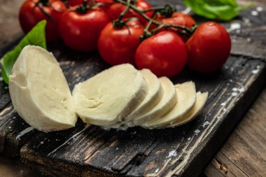 Mozzarella peyniri, fesleğen ve domates kirazı tahtada, kopyalama alanı. Caprese salatası için malzemeler. Metnin için boş yer.