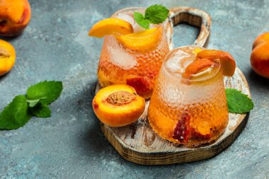 drinks peach, homemade peach cocktail with ice cubes, and mint in glass. Refreshing summer homemade non-alcoholic cocktails, Long banner format,