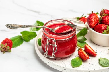 Beyaz arka planda bir kavanoz çilek reçeli. Ev yapımı çilekli marmelat ve meyve. Uzun pankart biçimi.