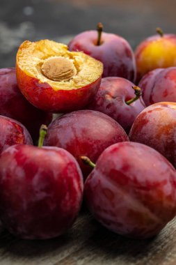 Taze erik. Koyu arkaplanda kırmızı erikler. dikey görüntü. en üstteki görünüm,