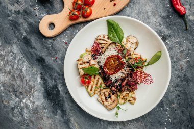 Izgara sebze, fındık, sos ve parmesanla dilimlenmiş biftek barbeküsü. İtalyan mutfağı konsepti. Üst Manzara. metin için yer.