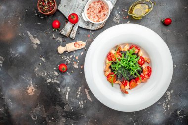 Karides ve kiraz domatesli siyah makarna. Lezzetli dengeli gıda konsepti, afiş, menü, metin için tarif yeri, üst görünüm,