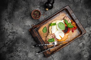 Lezzetli kahvaltı ya da haşlanmış yumurta ve kızarmış pastırmalı ekmek tostu. Sağlıklı yağlar, kilo vermek için temiz yiyecekler. Keto diyet konsepti. en üstteki görünüm.