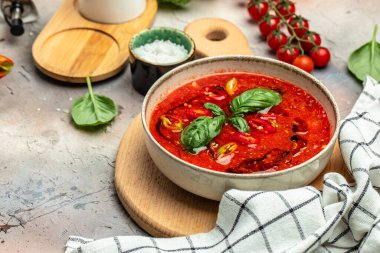 Geleneksel İspanyol usulü soğuk domates çorbası çorbası, arka planda hafif bir kasede. Temiz yemek, diyet, vejetaryen yemek konsepti. en üstteki görünüm.