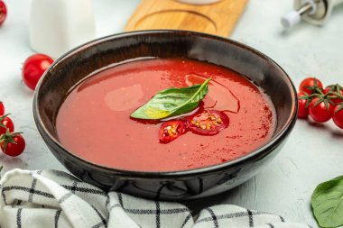 Arka planda fesleğenli püre domates çorbası. Temiz yemek, diyet, vejetaryen yemek konsepti. en üstteki görünüm.