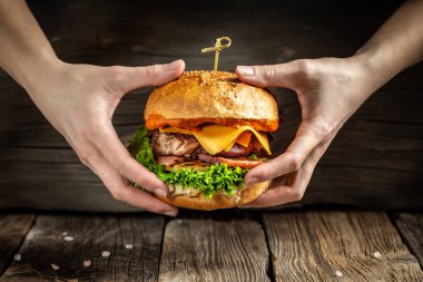 Ev yapımı burger, ızgara et, sebze, ahşap arka planda sos. Fast food ve abur cubur kavramı.