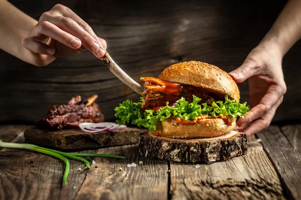 Tasty grilled homemade burgers with beef, tomato, cheese, bacon and lettuce on rustic wooden background. fast food and junk food concept.
