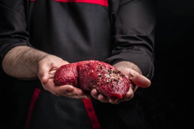 Biberiye ve baharatlı dondurulmuş biftekli şef tuzu. Karanlık bir arka planda taze et ya da domuz eti hazırlıyorum. Uzun pankart biçimi.