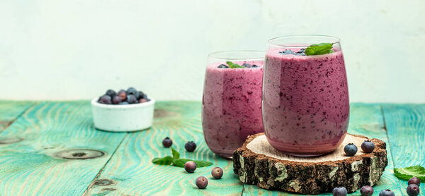 blueberry smoothie Yogurt fruit dessert on a blue background. Berry smoothie. healthy dieting concept. Long banner format.