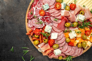 Aperatif masası. Koyu bir arka planda peynir, fuit ve et panosu. afiş, menü, metin için tarif yeri, üst görünüm.