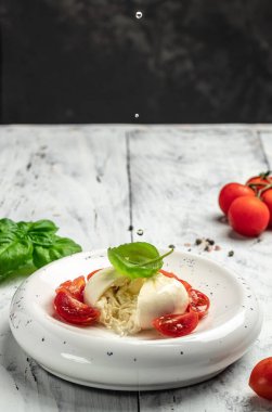 burrata cheese tomatoes on white plate on a light background. recipe top view.