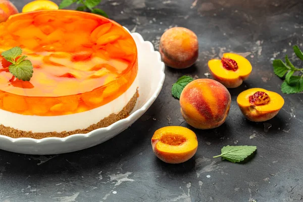 Layered cheesecake piece with peaches, peache jelly, jam. delicious sweet dessert piece of cheesecake. Homemade cream cake with peaches,