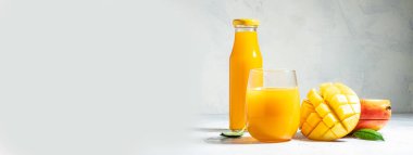Lezzetli bir mango içeceği ve arka planda taze meyveler. Uzun pankart biçimi.