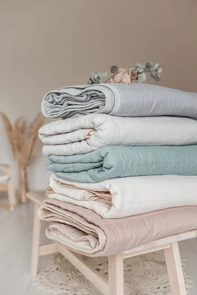 Stack of folded warm blankets with different design patterns. cotton blankets. Close up view of hypoallergenic Cotton bedding.