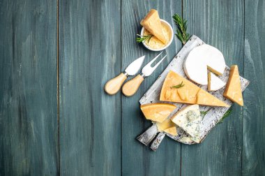 Parmesan peyniri. Cheeses set dor blu chedar camamber brie. Ahşap zemin üzerinde bıçak olan farklı peynir türleri. Uzun afiş biçimi. en üstteki görünüm.