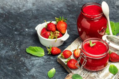 Cam kavanozda çilek reçeli ve sehpanın üzerinde taze böğürtlen. Uzun pankart biçimi.