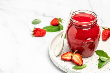 Cam kavanozda çilek reçeli ve beyaz masada taze böğürtlen. Uzun pankart biçimi.