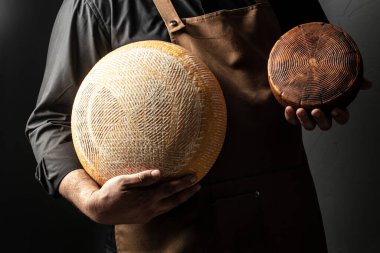 Yakışıklı cheesemaker peynirler onun atölye depolama denetliyor, yakın çekim.