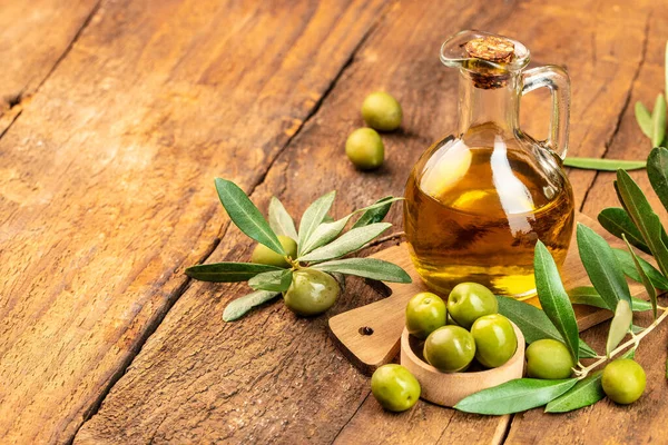green olives with olive oil. extra virgin olive oil jars on a wooden background. place for text.