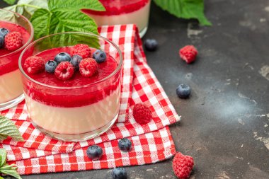 İtalyan tatlısı. Hafif arka planda ahududu reçelli ahududu panna cotta. Küçük kavanozlarda krema soslu böğürtlen tatlısı. Uzun afiş biçimi. metin için yer.