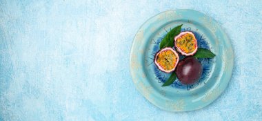 Mavi arka planda mor tutku meyvesi, uzun pankart formatında. en üstteki görünüm,