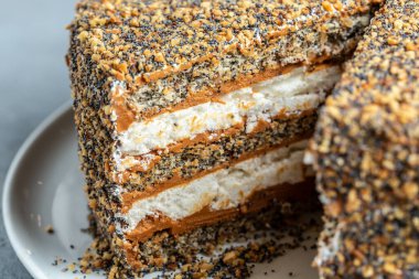 Katmanlı kek, üzerinde konsantre süt ve yemek tarifi olan fındıklı kek. Kapatın. Katmanlı haşhaşlı kek.,