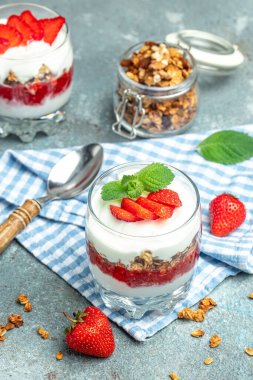 Yoğurtlu parfe, granola, reçel, taze böğürtlen ve cam kavanozda nane yaprağı. Glütensiz diyet, sağlıklı kahvaltı. dikey görüntü. metin için yer.