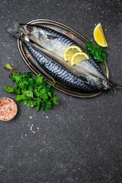 marinated mackerel or herring fish with salt, lemon and spices on a metal tray. Seafood concept. vertical image. top view. place for text.