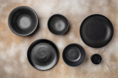 Bej arka planda boş plakalar. Çeşitli el sanatları tabakları koleksiyonu. El yapımı seramik. en üstteki görünüm.