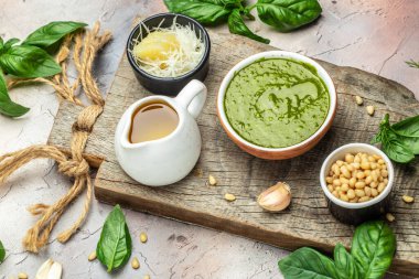 Green basil pesto with italian recipe ingredients, Basil, olive oil, parmesan, garlic, pine nuts. banner, menu, recipe place for text, top view,
