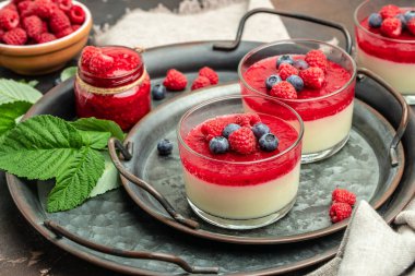 Krem şanti ve naneli ahududu şerbeti. Küçük kavanozlarda siyah arka planda İtalyan tatlısı. metin için yer.