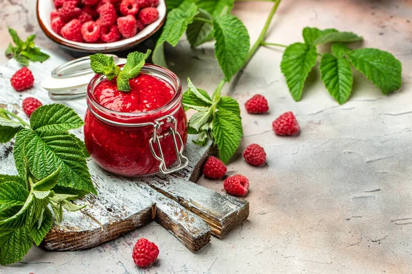Raspberry jam with berry on light background. Homemade jam with raspberry. banner, menu, recipe place for text, top view.