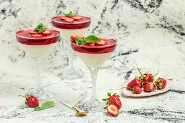 Çilekli krema, organik yoğurtlu panna cotta, hafif arka planda çilekli ve naneli. Yazlık yoğurt tatlısı. Metin için boşluk,