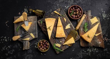 Tahtada parmesan peyniri, sert peynir, arka planda biberiye ve peynir bıçağı. metin için yer, üst görünüm.