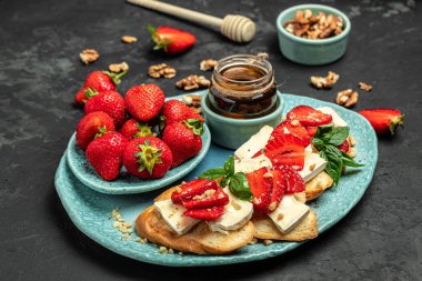 İçinde çilek, peynirli camembert fındığı ve koyu arkaplanda bal olsun. Yemek tarifi geçmişi. Kapat..