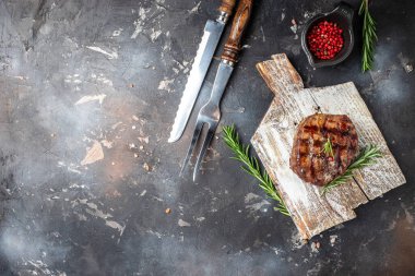 Grilled beef steak on a wooden board. banner, menu, recipe place for text, top view.