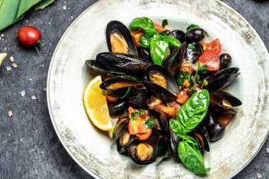 Cooked mussels with lemon and parsley on table. Food recipe background. Close up.