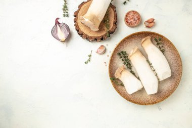 Pleurotus eryngii mushrooms on a light background, banner, menu, recipe place for text, top view,