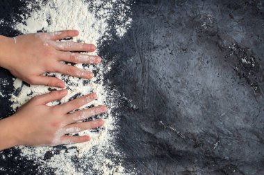 Woman adds some flour to dough. baking background, banner, menu, recipe place for text, top view.